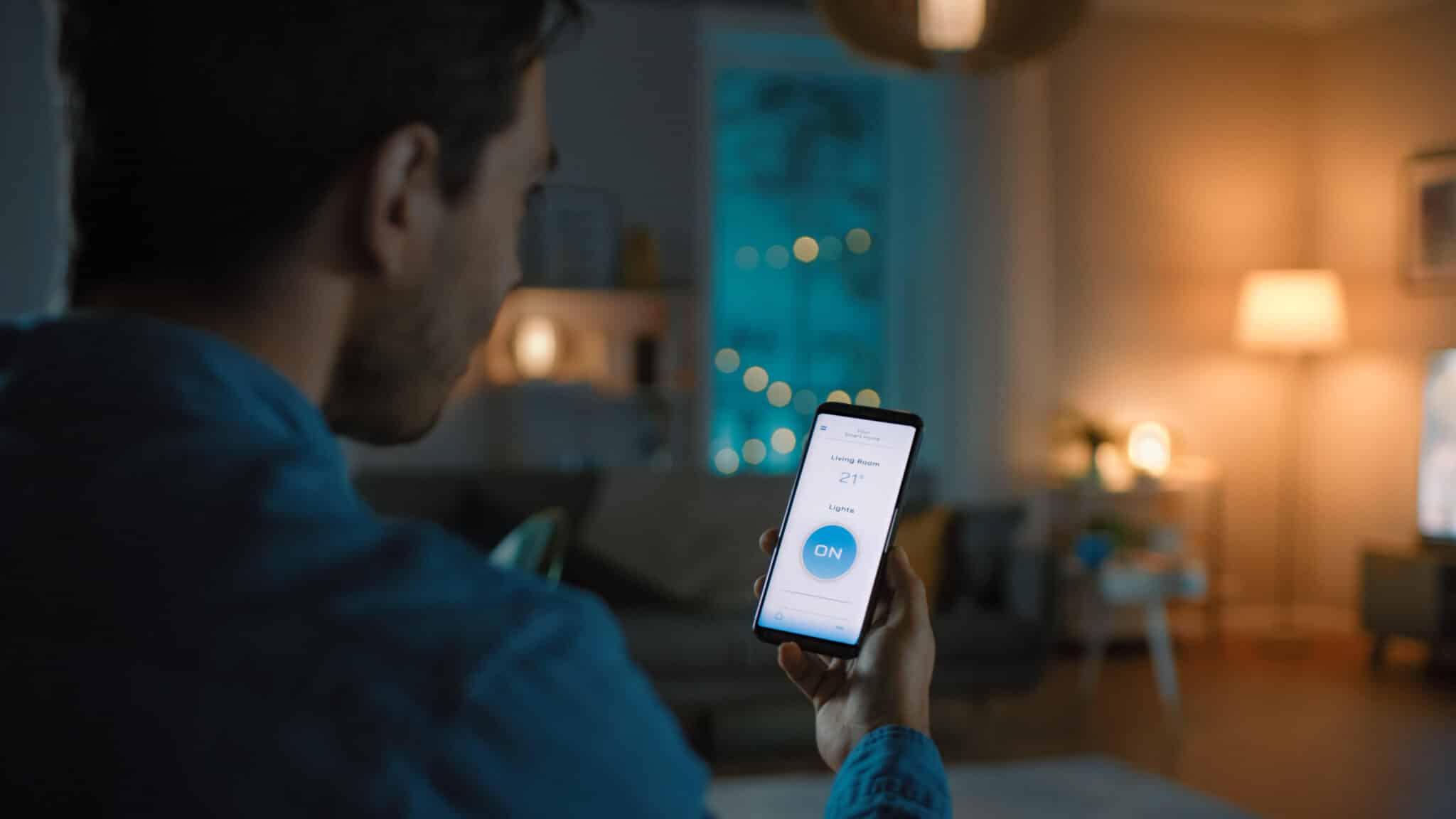 Voice command to a smart home application on his smartphone to switch on the lights and set a comfortable temperature, Modern Lighting Solutions.
