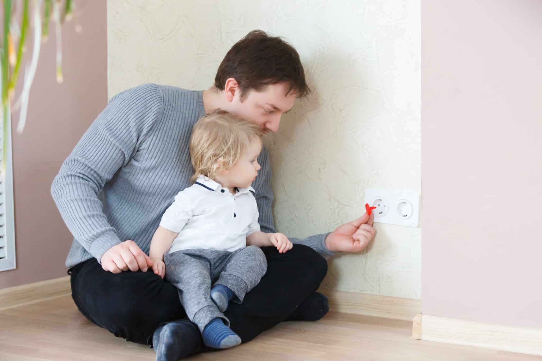 Father takes care of the safety of the child. Electrical security for safety home, Residential Electrical Safety.